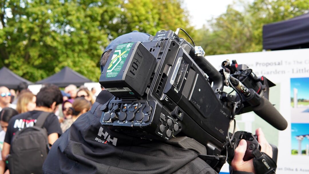 Journalist reporting live outdoors with a cameraman